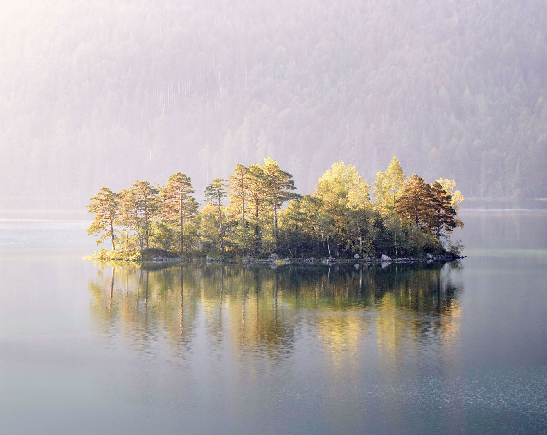 A woman sitting quietly by the sea in soft morning light
